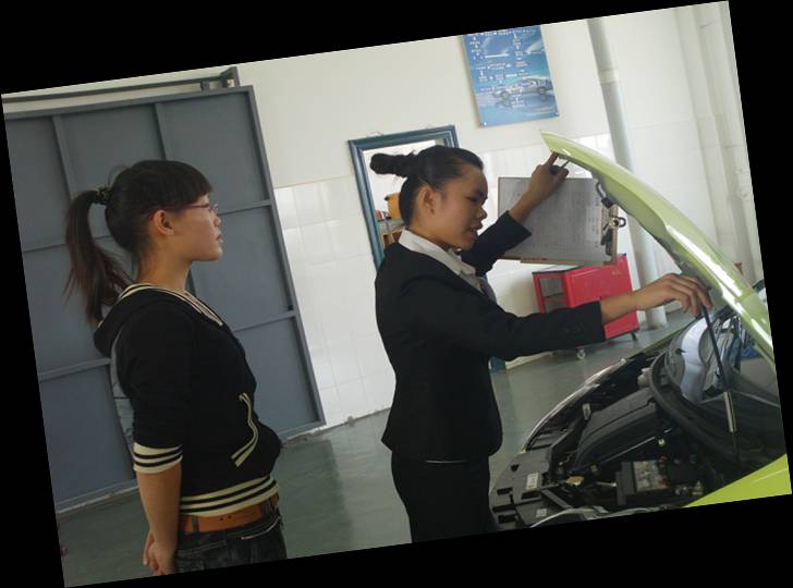 图三 汽车维修接待项目比赛选手李艳正在与顾客一起检查发动机