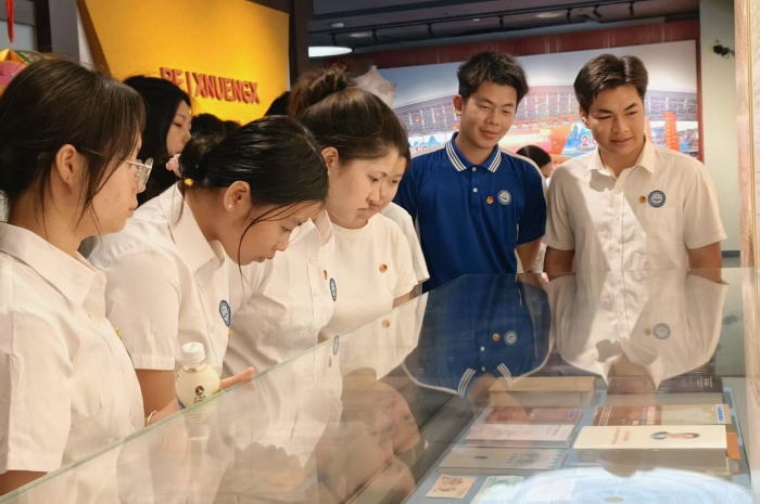 青年团员近距离观察钱币展品上的壮文.JPG.jpg